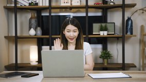Asian woman using laptop making video call for distant meeting or online support working from home while coronavirus pandemic
