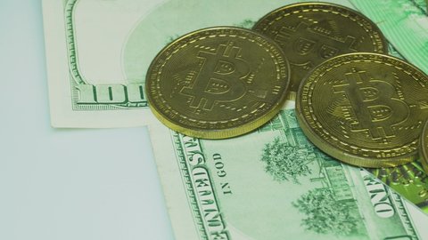 Put a pile golden Bitcoins on a background of dollars.Close-up bitcoins. Exchange bitcoin for cash to a dollar. Crypto currency.