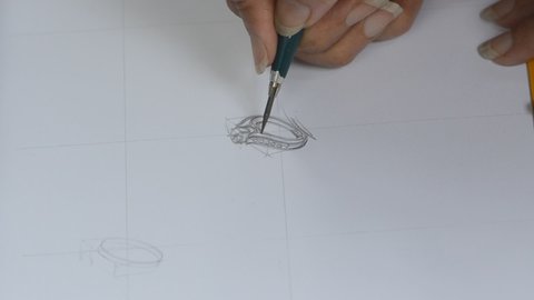 The designer is sketching a picture of the jewelry ring.