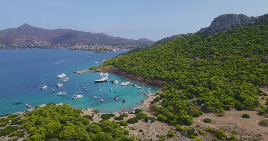 Ascending drone shot of moored yachts and catamarans on a beautiful bay for diving