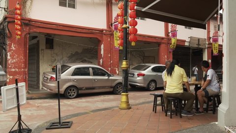 Johor Bahru, Johor, Malaysia - 12 15 2019: Wide Angle shot of Chinese family eating outdoors near the sidewalk at a cafe in Johor Bahru, Malaysia.