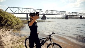 Relaxing Woman Cyclist Taking Selfie Video When Riding On Bicycle.Fitness Girl Cyclist Taking Selfie Photo.MTB Cycling On Countryside Road.Taking Break Intensive Workout Pedaling On Gravel Bicycle.