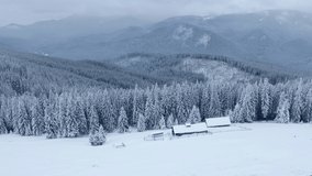 4k drone forward video (Ultra High Definition) of mountain chalet. Snowy winter scene of Carpathian mountains, Ukraine. Europe. Traveling concept background.