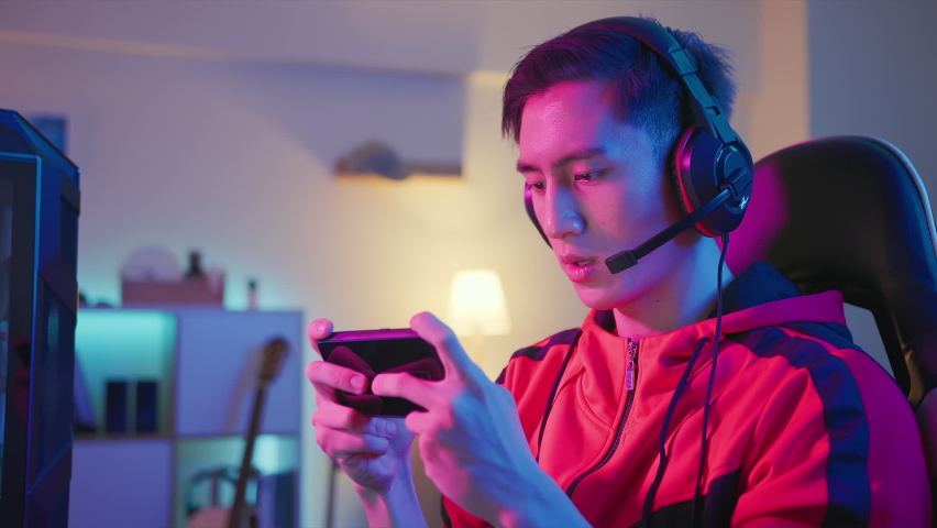 asian man have live stream and playing mobile game on the smartphone at home Royalty-Free Stock Footage #1073880194