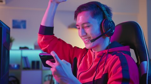 asian man have live stream and playing mobile game on the smartphone at home