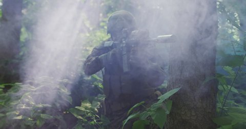 Silhouette of the Fully Equipped Soldier Moving Through Smokey Forest. Military action