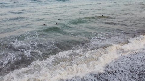Grabación aérea de unos surfistas nadando entre las olas del mar de Fuengirola (Málaga).