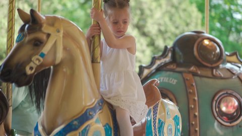 Little girl ride Horse Old Fashioned French Carousel, Roundabout. Handheld Handshake effect High quality 4k footage