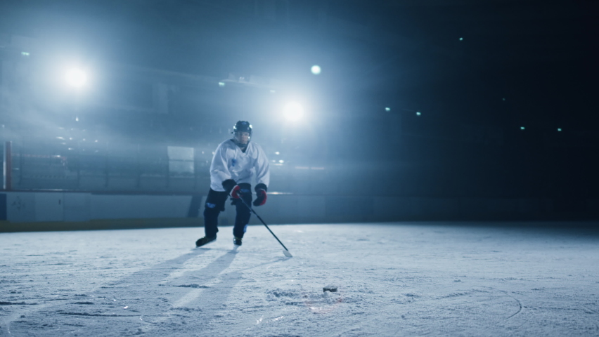 Ice Hockey Rink Arena: Professional Shot the Puck with Hockey Stick. 3D Animation Flying Puck Has Tracking Markers for Brand Logo Insertion. Scoring a Goal. Wide Shot, Cinematic Lighting, Slow Motion Royalty-Free Stock Footage #1073888339