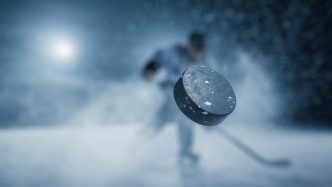 Ice Hockey Rink Arena: Professional Shot the Puck with Hockey Stick. 3D Animation Flying Puck Has Tracking Markers for Brand Logo Insertion. Scoring a Goal. Wide Shot, Cinematic Lighting, Slow Motion