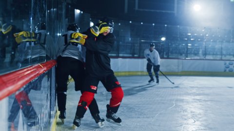 Ice Hockey Rink Arena: Professional Defender Player Attacks, Boarding Attacker Aggressively, Taking away the Puck. Competitive Intense Game with Amazing Skills, Speed, Energy, Power. Fast Slow Motion