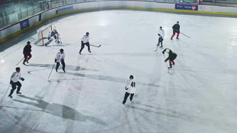 Ice Hockey Rink Arena: Great Team Play, Perfect Passes, Masterful Dribbles, Break Defense, Result in a Scored Goal. Beautiful Energetic Game from Professional Star Team. Cinematic High Angle Long hot
