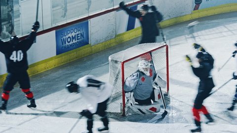 Ice Hockey Rink Arena: Professional Forward Player Masterfully Dribbles, Breaks Defense, Hitting Puck with Stick Scores Goal, Goalie Missed it. Fast, Energetic, Cinematic High Angle Wide Shot