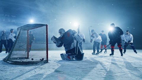 Ice Hockey Rink Arena: Goalie against Forward Player who Does Slapshot, Shots Puck with Stick and Scores Goal. Forwarder againstGoaltender.Team Celebrates. Cinematic Slow Motion Behind Goals Wide Shot