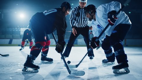 Ice Hockey Rink Arena Game Start: Two Players Brutal Face off, Sticks Ready, Referee Drops the Puck, Athletes fight for It. Intense Game Wide of Energy Competition, Speed. Cinematic Slow Motion