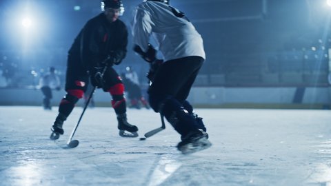 Ice Hockey Rink Arena: Young Players Training, Learning Stick and Puck Handling. Athletes Learn how to Dribble, Attack, Defense, Protect, Possession, Carrie the Puck. Cinematic Slow Motion Medium Shot