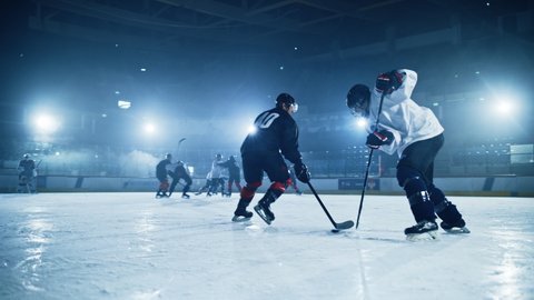 Ice Hockey Rink Arena: Young Players Training, Learning Stick and Puck Handling. Athletes Learn how to Dribble, Attack, Defense, Protect, Possession, Carrie the Puck. Cinematic Medium Shot