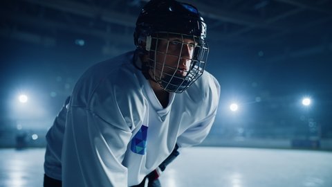 Ice Hockey Rink Arena: Confident Professional Player Suddenly Starts an Attack. Portrait of the Young Athlete, Determined to Win Championship, Ready to Hit that Goal. Cinematic Bokeh Shot