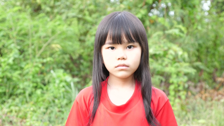 
Little girl smiling and looking at camera park background.
Asian portrait child  hand waving goodbye.