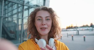 POV of Caucasian happy positive woman videochatting on street in town smiling while standing outdoors. Close up of cheerful female speaking on video call online in good mood. Communication concept
