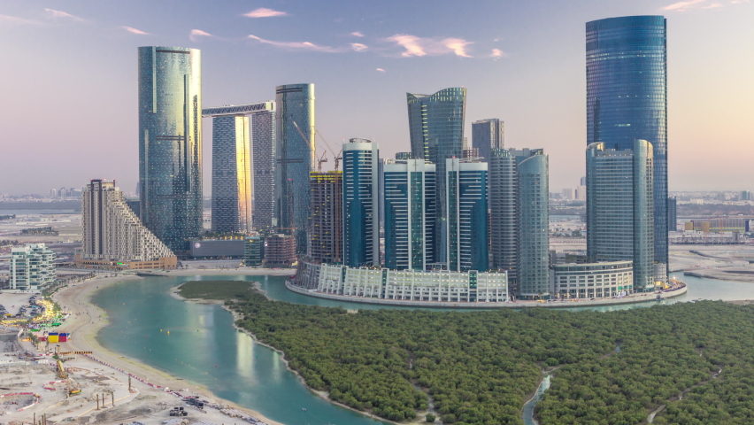 Skyscrapers on Al Reem Island in Abu Dhabi day to night transition timelapse after sunset from above. Aerial citiscape from Al Reem Island with illuminated buildings Royalty-Free Stock Footage #1073894879
