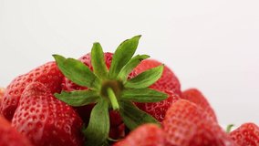 Ripe and fresh red strawberries on a white background close-up macro footage