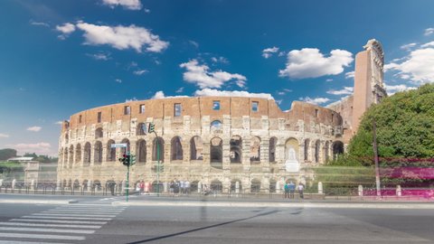 Many tourists visiting The Colosseum or Coliseum timelapse hyperlapse, also known as the Flavian Amphitheatre in Rome, Italy. Traffic on the road. Blue sky with clouds at sunny day