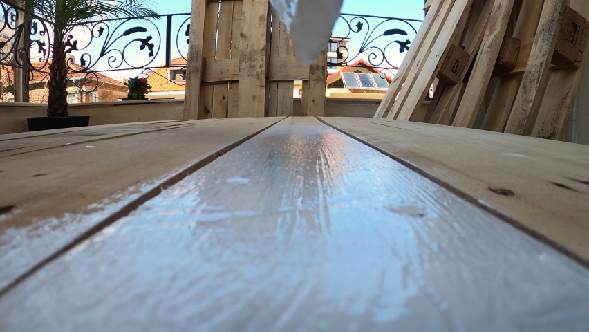 Close Up Shot of Paintbrush Painting Old Wood Pallets With White Paint; Renovating and Building Wooden Furniture