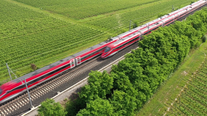 Two trains of red color movement aerial view. The movement of trains at high speed between the vineyards, top view.