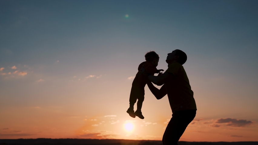 Silhouette of happy family. Father and son in park. Father tosses son up. Happy family concept. Father plays with son in park. Family silhouette. Father tosses his son up. Silhouette of happy family Royalty-Free Stock Footage #1073914289