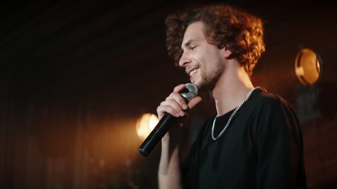 CU PORTRAIT of Young Caucasian male comedian performing his stand-up monologue on a stage of a small venue. Shot with ARRI Alexa Mini LF with 2x anamorphic lens