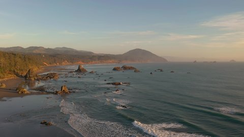 Drone flies over sea stacks in Port Orford during warm afternoon light