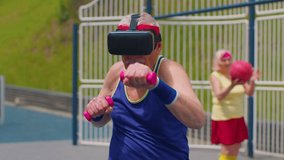 Elderly sportsman grandfather in virtual reality VR 3D headset do training sport fitness boxing aerobics cardio exercising with dumbbells on playground. Senior old grandmother playing ball basketball - Powered by Shutterstock - Get 15% off with code: PIKWIZARD15