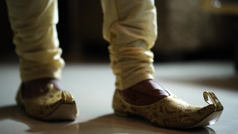 When the groom is going to the wedding, he is wearing shoes on his feet.