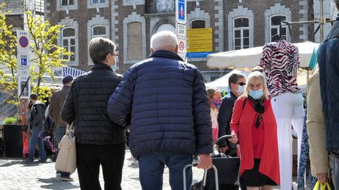 Tongeren , Belgium - 05 13 2021: People with face masks walking at city market in Tongeren during coronavirus pandemic.