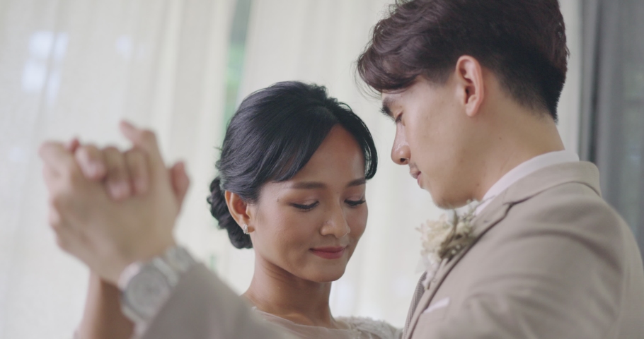 Close up Happy Asian Bride And Groom In Wedding Dress Prepare For Married In Wedding Ceremony. Romantic Moment Of Man And Woman Couple Dancing Together. Royalty-Free Stock Footage #1073937056