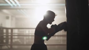 Blurred view, woman fighter trains his punches, beats a punching bag, training day in the boxing gym, strength fit body, the female strikes fast. - Powered by Shutterstock - Get 15% off with code: PIKWIZARD15