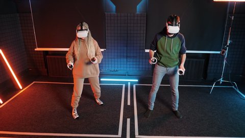 People play artificial drumming Oculus Rift VR game. Couple play virtual reality simulation. Male and female in gaming headsets musical drums competition. Music gamer person in vr glasses headset.