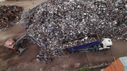 Hull , east yorks , United Kingdom (UK) - 05 17 2021: Aerial footage of a lorry unloading scrap metal onto the dockside next to a pile of scrap metal for recycling