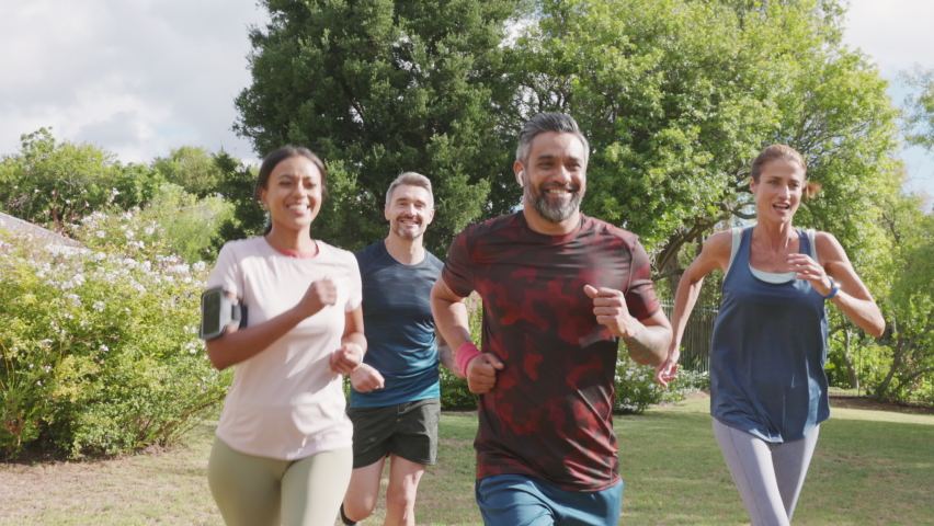 Healthy group of multiethnic middle aged men and women jogging at park. Happy mixed race couples running together. Mature friends running together outdoor. Royalty-Free Stock Footage #1073952977