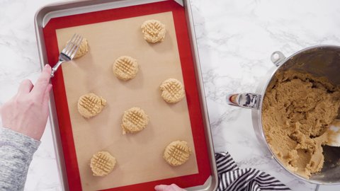 Time lapse. Flat lay. Step by step. Scooping peanut butter cookies dough with dough scooper into the baking sheet.