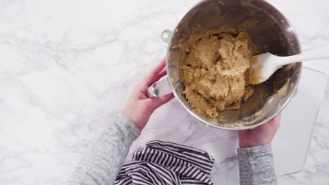 Flat lay. Step by step. Scooping peanut butter cookies dough with dough scooper into the baking sheet.