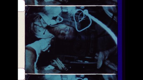 1969 Outer Space. Astronaut Michael Collins inside Command Module Columbia Orbits the Moon as Neil Armstrong and Buzz Aldrin Land on the Moon. The 4K Overscan of Vintage Archival 16mm Film Print