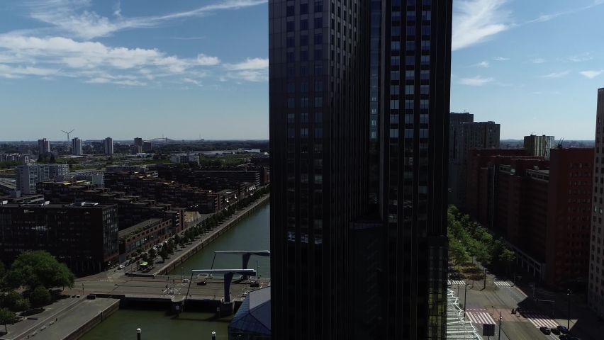 Aerial view of Rotterdam skyline moving up in front of modern office building located in the city center looking south east showing Spoorweghaven Stieltjesstraat and further urban neighborhood 4k