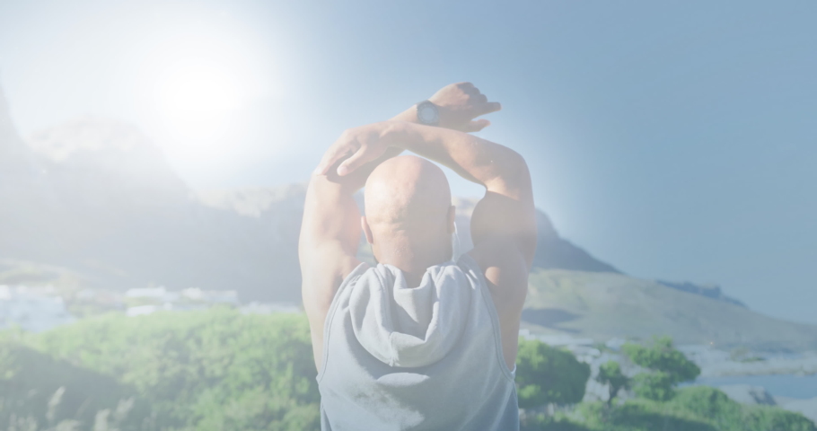 Animation of glowing lights over senior man exercising and clouds background. retirement and senior life concept digitally generated video.