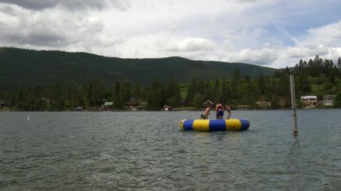 Kalispell , MT , United States - 06 25 2020: Youth Camp Teens Jumping on Trampoline on Flathead Lake