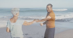 Animation of glowing light over portrait of happy senior couple dancing by seaside. retirement and senior life concept digitally generated video.