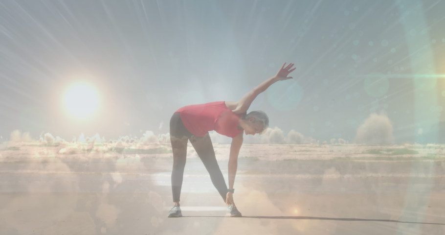 Animation of glowing light over portrait of senior woman exercising. retirement and senior life concept digitally generated video.