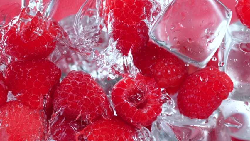 Super Slow Motion Shot of Pouring Water on Raspberries and Ice Cubes in Glass at 1000 fps.