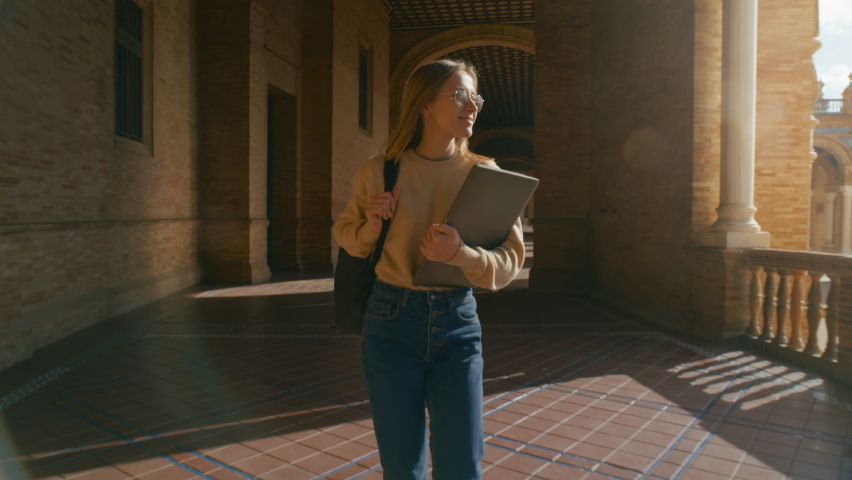 Excited young female student walk for first time through corridors of university campus. Beautiful happy woman, ready to learn and gain new experience. Higher education abroad or exchange Royalty-Free Stock Footage #1073978294